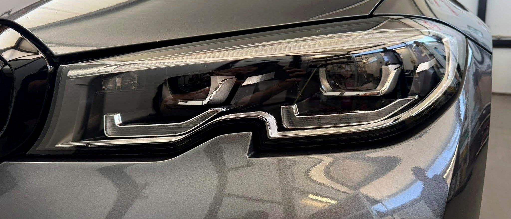 Макро кадър на модерен LED фар по време на полиране в Makashi Garage